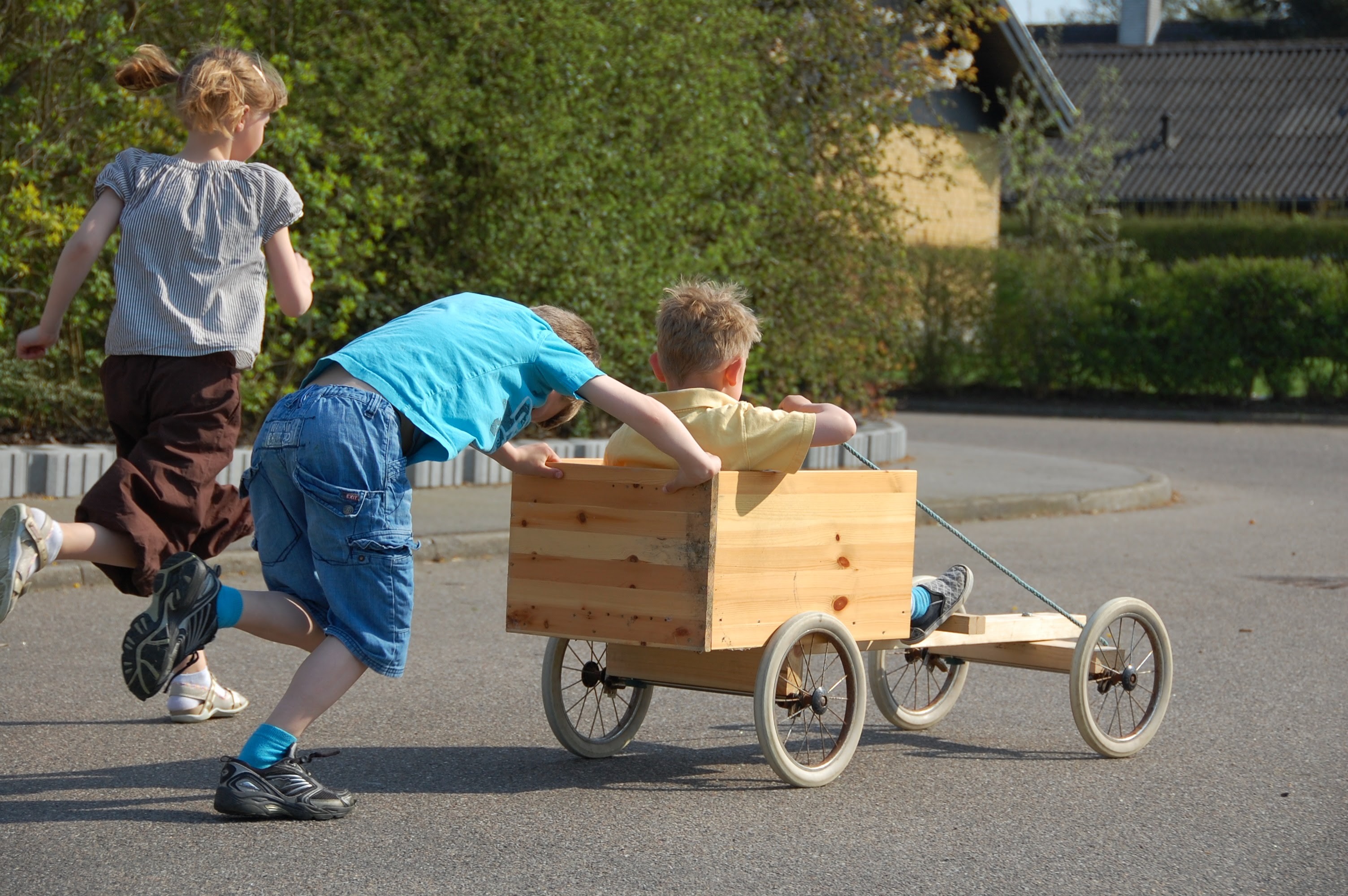 Kids pushing a homemade cart down a Danish street