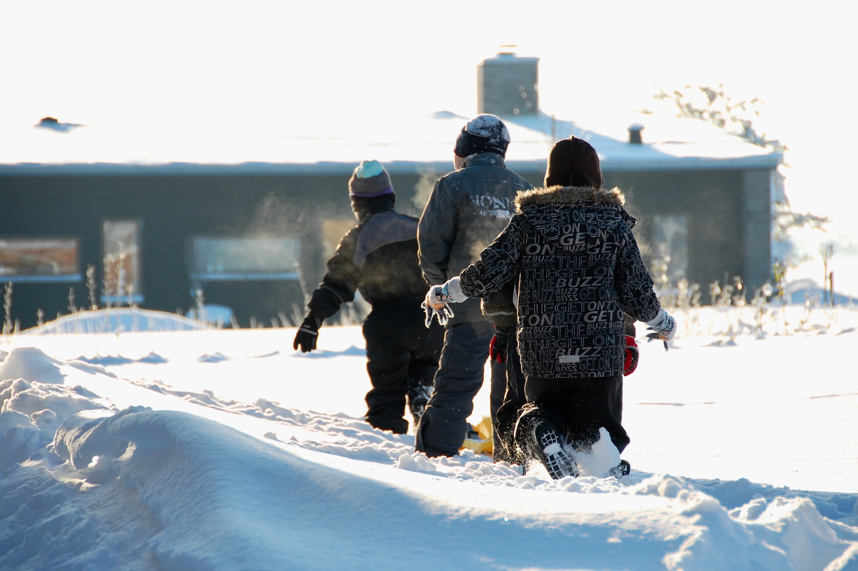 Kids running through deep snow in low winter sun